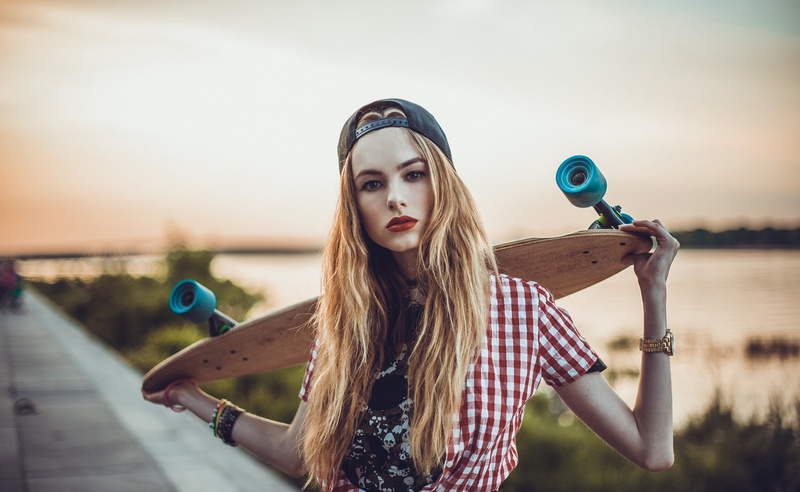 model, looking at viewer, 1080P, blonde, long hair, Maxim Vasechko, women, shirt, baseball caps, depth of field, portrait, face, wavy hair, longboard