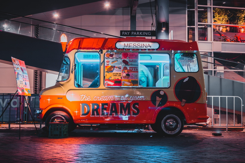 land vehicle, gray, van, street, red, dreams, text, architecture, building exterior, western script, outdoors, bus, built structure, sign, building, city