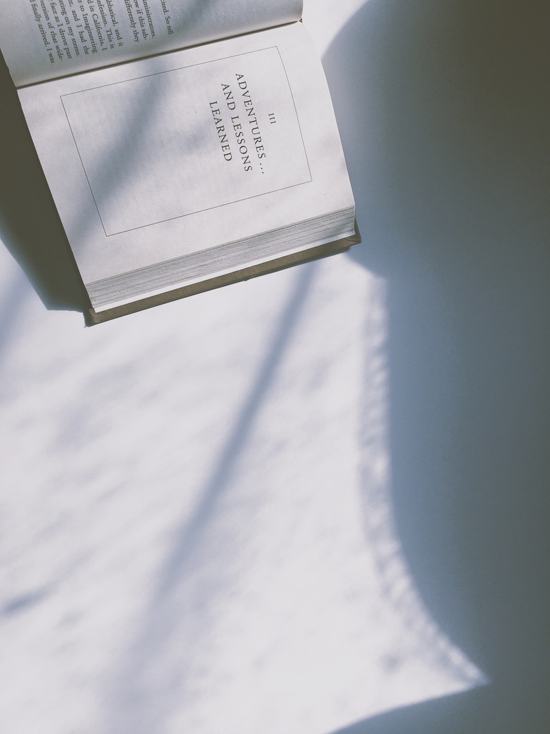letter, blue, western script, indoors, paperwork, iii, lessons, typography, mail, book, novel, chapter, shadow, white, culture, note pad, high angle view