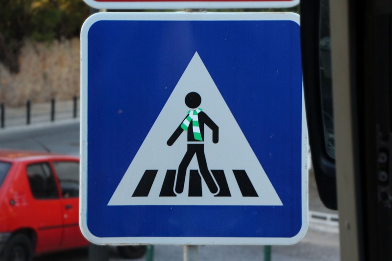 pedestrian crossing sign, 1080P, sign, focus on foreground, shape, outdoors, scarf, information symbol, road, blue, communication, transportation, guidance