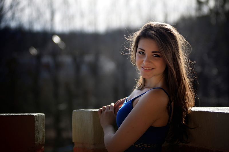 focus on foreground, smiling, model, looking at camera, happiness, beauty, long hair, beautiful woman, 1080P, casual clothing, portrait, one person, sitting