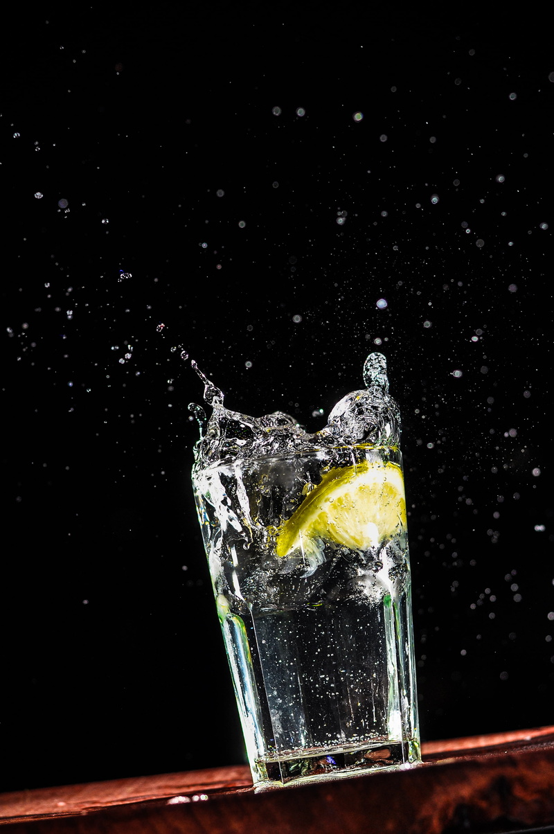 glass, lemon, studio shot, drinking, black background, alcohol, motion, splashing, fruit, cold temperature, drink, liquid, cocktail, food and drink, food