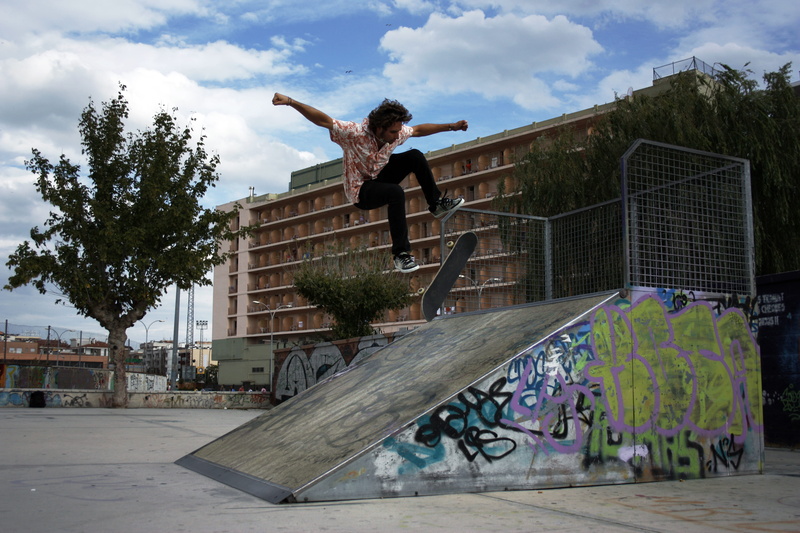 colors, arms raised, pirate, architecture, skateboard park, kickflip, jumping, spain, skate, day, mid-air, stunt, people, skill, sky, human arm, cloud - sky