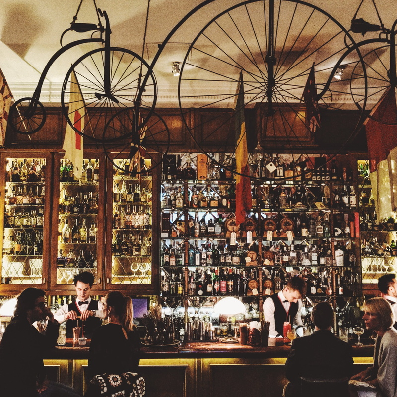 architecture, wheel, alcohol, built structure, drinks, talking, adult, store, bar - drink establishment, sitting, 2K, ceiling, women, food and drink, real people