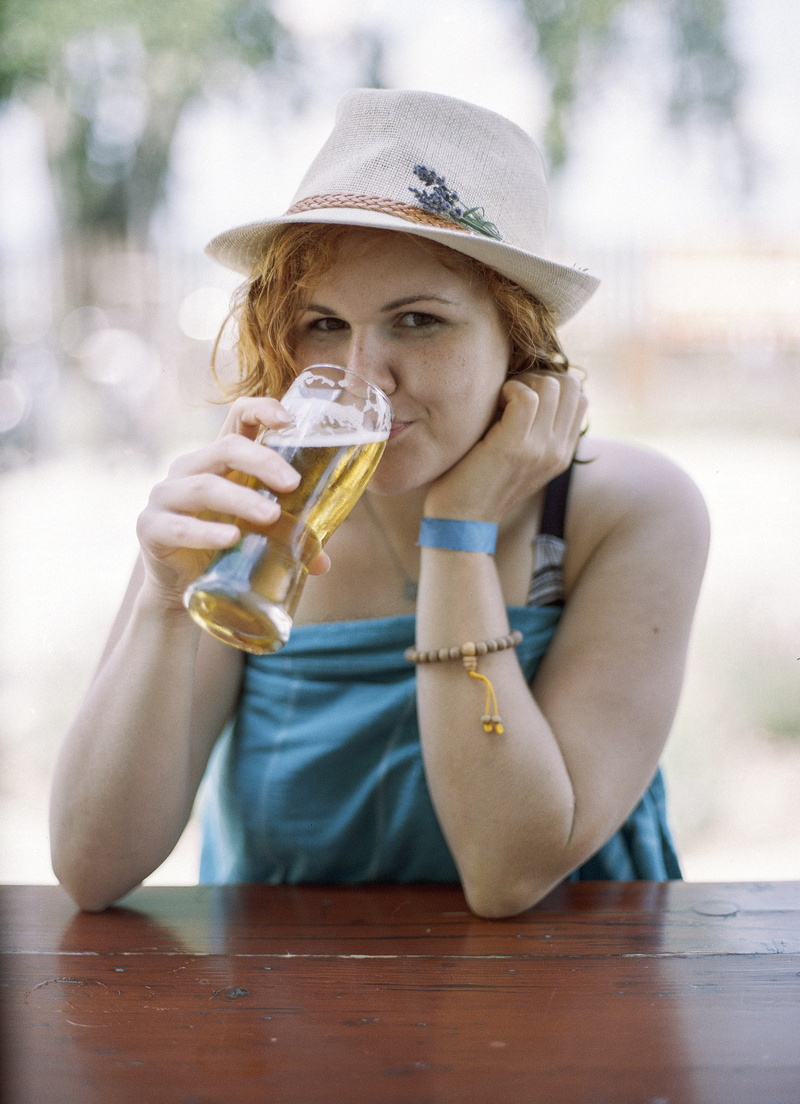 people, focus, hat, person, hair, lifestyles, young, glass, beach, cheerful, parfait, sitting, portrait, shallow, beer, clothing, table, refreshment, looking at camera