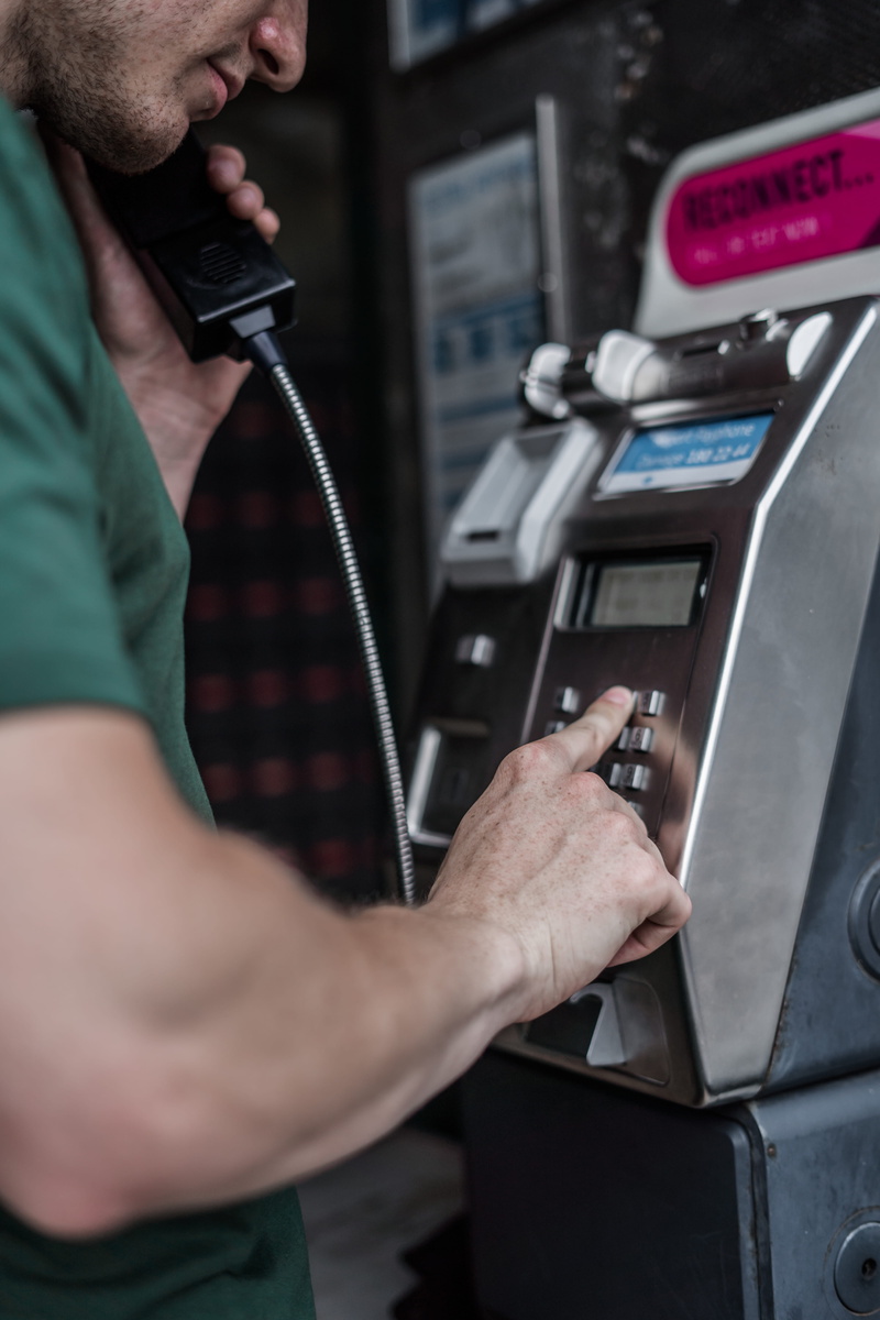 midsection, person, machinery, dialing, public phone, technology, machine, occupation, side view, mid adult, one person, phone box, shirt, dial, working