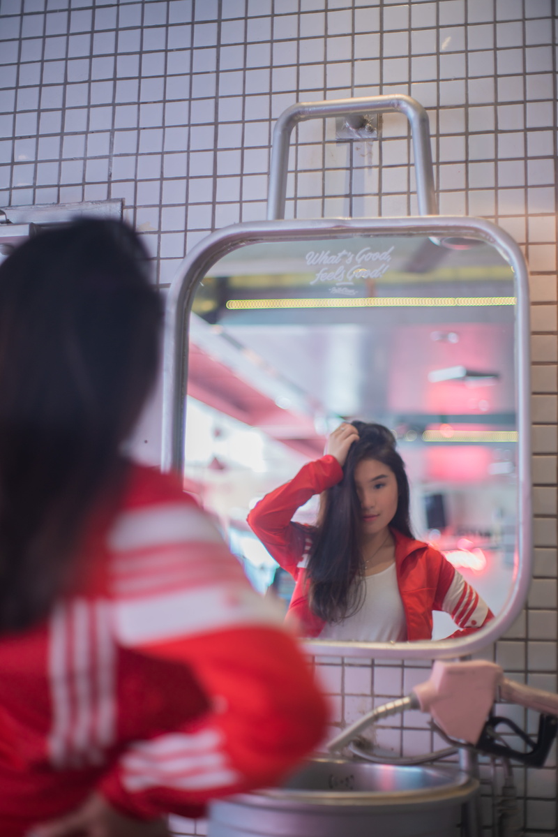 female, casual clothing, hairstyle, kid, human, girl, sitting, women, young adult, headshot, person, focus on background, child, mirror, set, machine, people