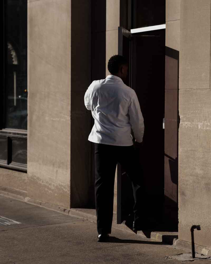 building exterior, human, walking, well-dressed, outdoors, architectural column, apparel, pedestrian, built structure, sliding door, atm, cash machine
