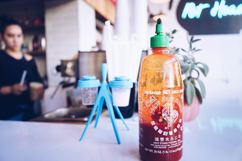 food and drink, container, half, sriracha, close-up, sign, condiment, rack, glass - material, shaker, retail, filled, still life, drink, bottle, hot, gray