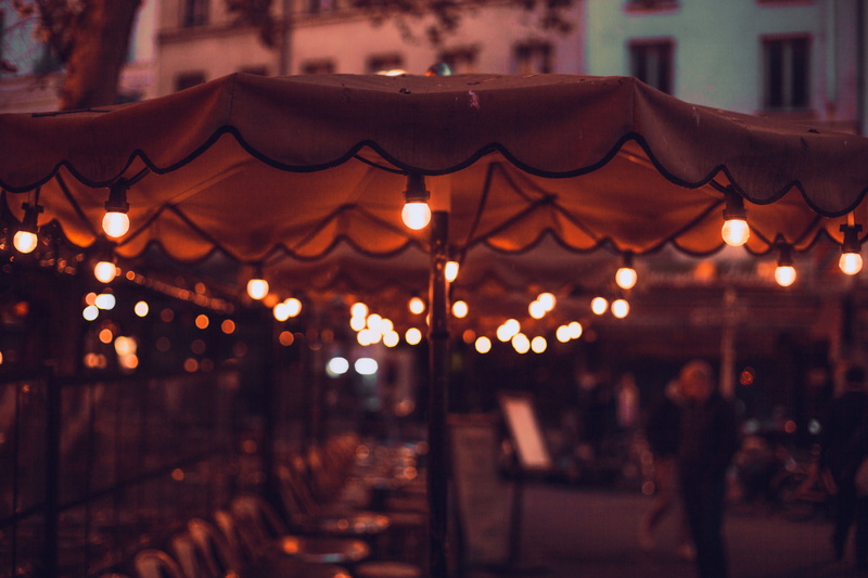 focus on foreground, cafe, cafeteria, lamp, people, pub, lot, night, architecture, celebration, incidental people, lighted, illuminated, decoration, arts culture and entertainment