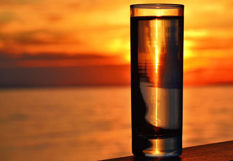evening, dusk, orange color, no people, sunlight, sea, food and drink, hour, single object, clear, clouds, ocean, outdoors, sunset, glass, seascape, table