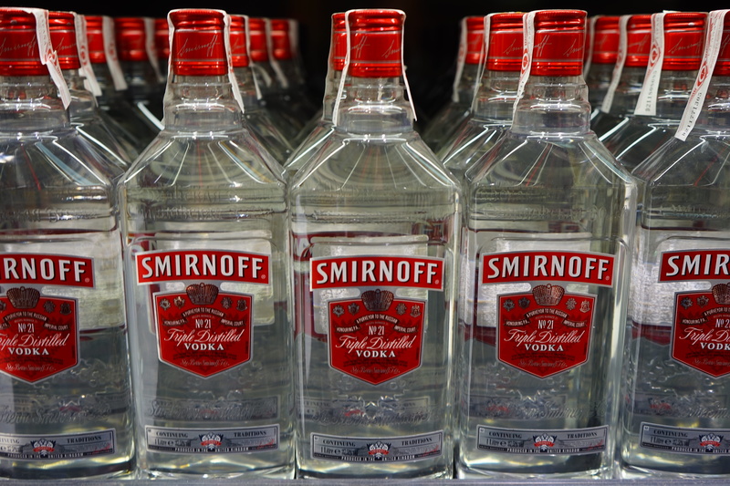 in a row, text, lot, red, glass - material, alcohol sales, for sale, container, food and drink, glass, diageo, alcoholic, alcohol, western script, smirnoff