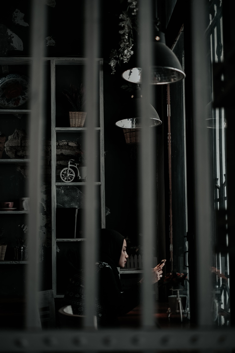 lighting, closet, furniture, door, sitting, using, selective focus, cupboard, adult, bookcase, business, real people, screen, china cabinet, smartphone