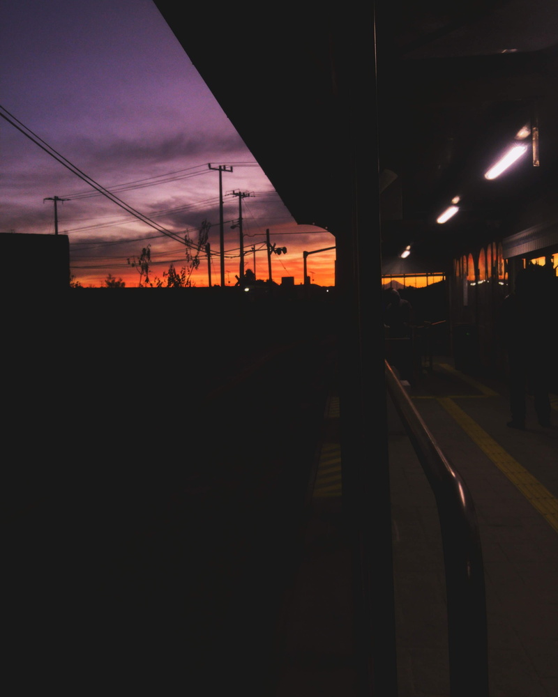 night, rail transportation, sunset, luces, silhouette, dawn, lighting equipment, track, bus stop, mode of transportation, outdoors, sky, architecture, power line
