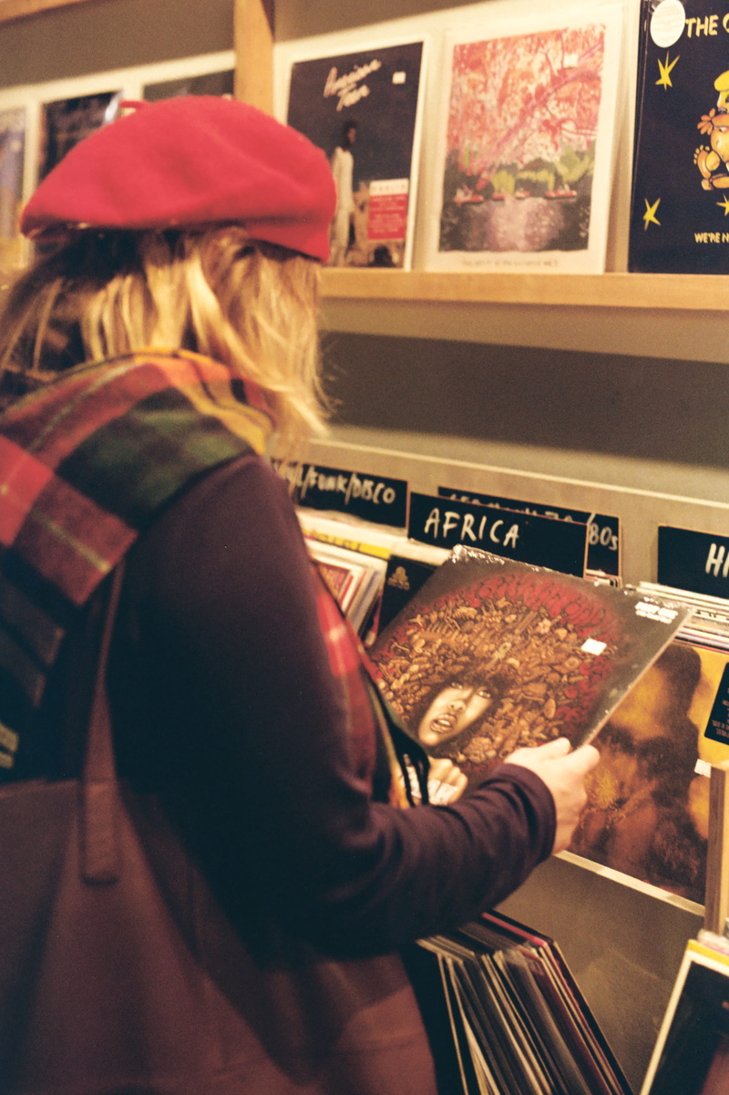 sitting, record hunting, one person, lifestyles, females, shopping, leisure activity, waist up, store, hipster, rear view, music, vinyl, arts culture and entertainment