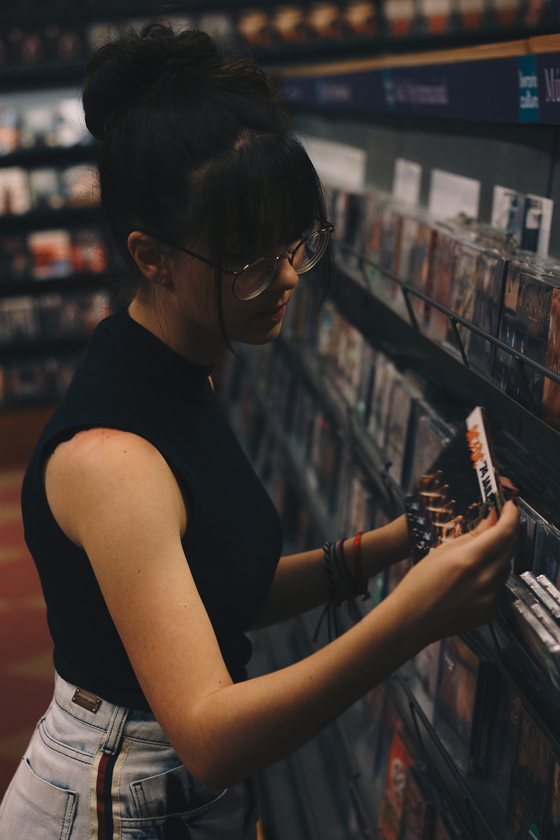 retail, arts culture and entertainment, woman, women, cds, glasses, rack, case, display, lifestyles, black, music, indoors, pose, beauty, holding, cd, adult