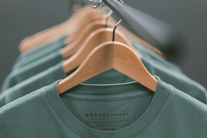 focus on foreground, gracechapel, rack, retail, t shirt, black, 8K, hand, detail, no people, photography, wood - material, selective, metal, green, white