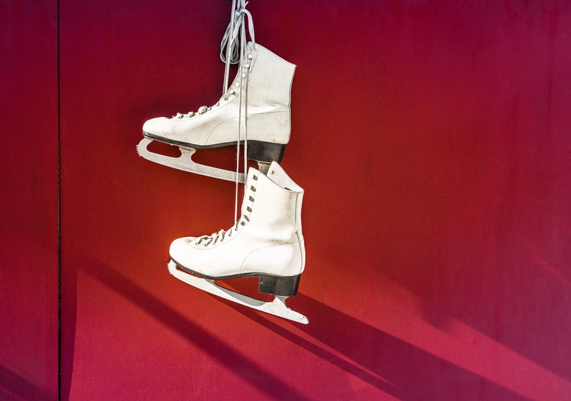 ice skates, ice-skating, colored background, indoors, pair, lifestyles, white, blades, white color, womenswear, hanging, hanged, wall - building feature