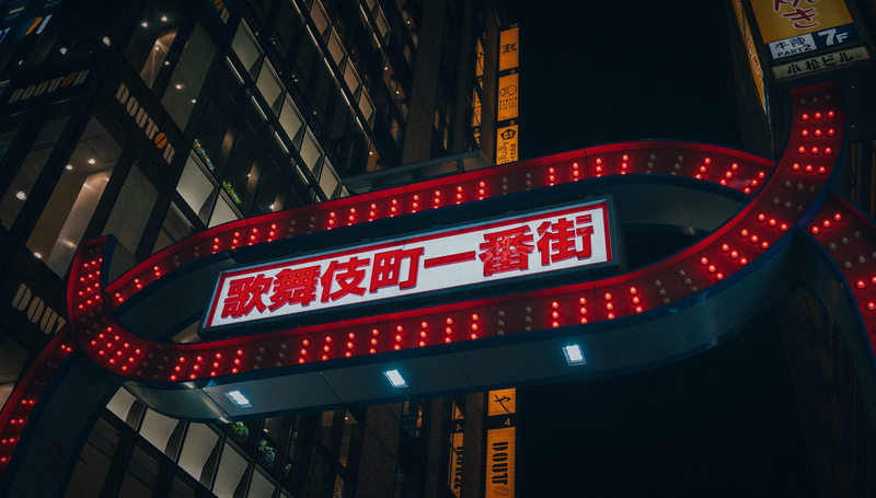 western script, building, information sign, night, downtown, arts culture and entertainment, illuminated, housing, travel, red, bowl, built structure, road