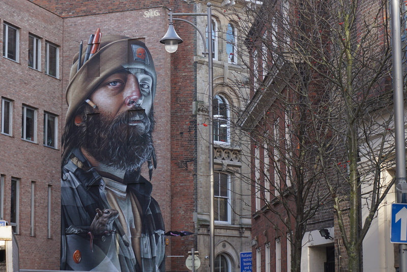 warm clothing, jacket, art, pirate, tree, brick, man, fireman, steeple, plaque, building exterior, outdoors, clothing, standing, 4K, human, poster, leafless