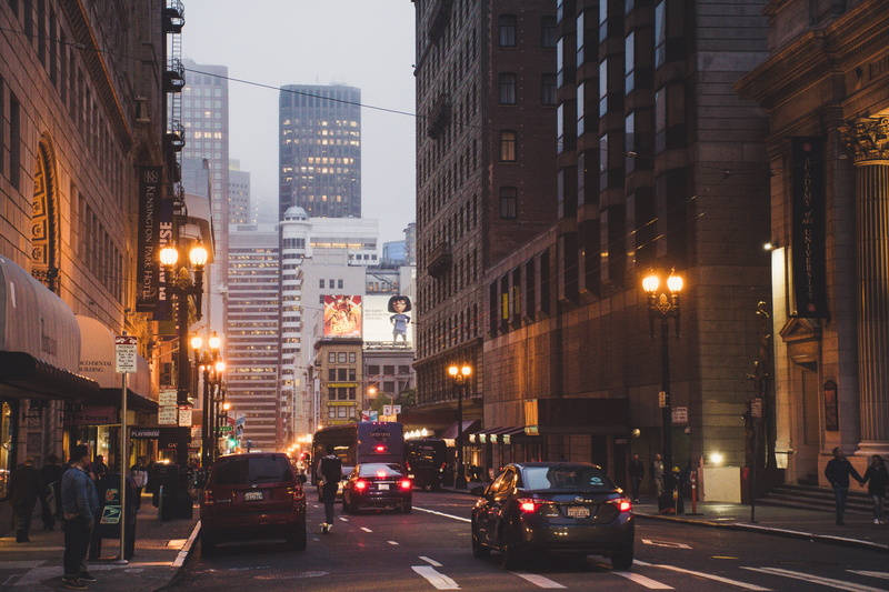 transportation, motor vehicle, downtown, building exterior, offices, modern, people, cityscape, commerce, incidental people, beside, evening, streetlights
