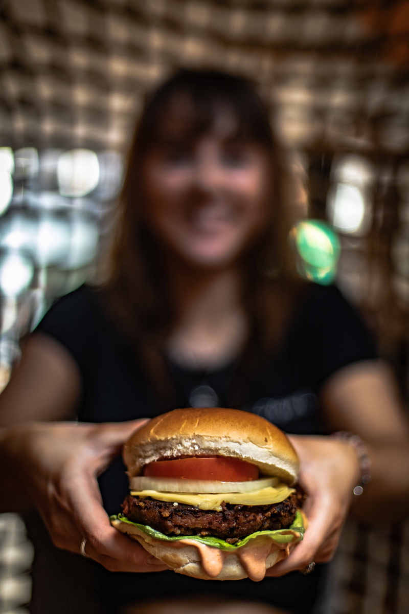 indoors, soda, food, bun, fast food, front view, focus on foreground, ready-to-eat, meat, restaurant, focus, real people, cornbread, eating, person, unhealthy eating