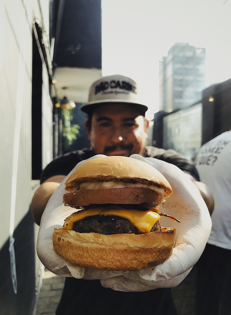 holding, apparel, clothing, sandwich, bread, fast food, rua estela sezefreda, human, unhealthy eating, pinheiros, curry, meal, focus on foreground, one person