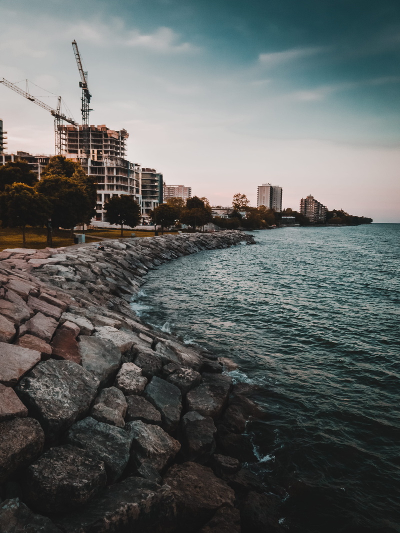 rock, water, sky, skyscraper, blue, ocean, burlington, canada, beach, cloud - sky, burlington beach, high rise, coast, tree, sea, architecture, city, land