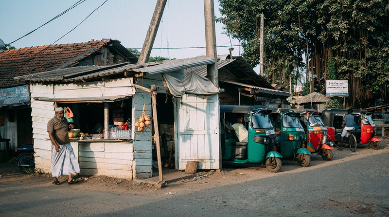 day, casual clothing, city, full length, market, building, real people, tree, lifestyles, tuk tuk, one person, road, 2K, kalpitiya, adult, stall, village
