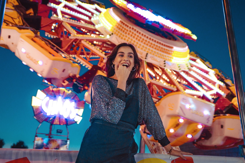 amusement park, fun, adult, standing, yellow, smiling, wear, young adult, near, low angle shot, casual clothing, women, night, three quarter length, front view