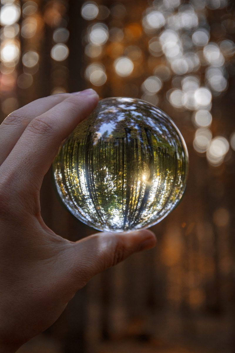 human hand, human body part, body part, focus on foreground, sphere, globe, human finger, finger, lifestyles, real people, shiny, glass items, crystal