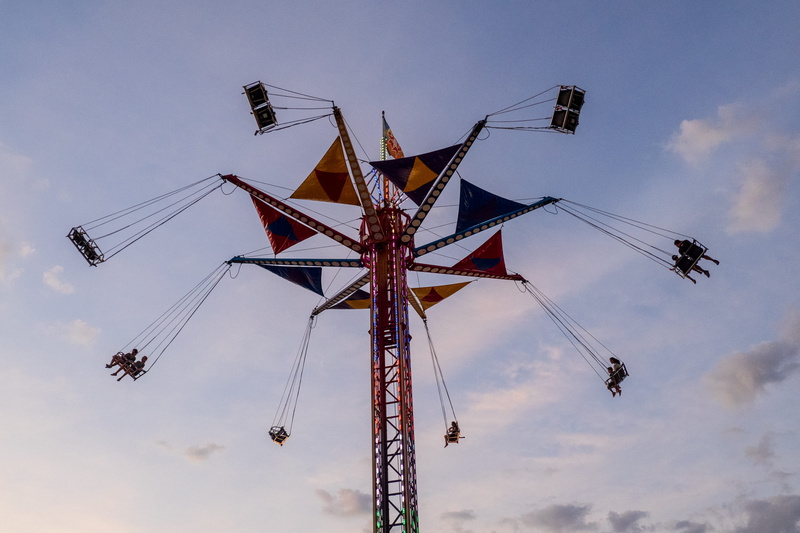 group of people, cable, sky, airplane, aircraft, hanging, toy, amusement park ride, vehicle, theme park, blue, person, leisure activity, crowd, fairground