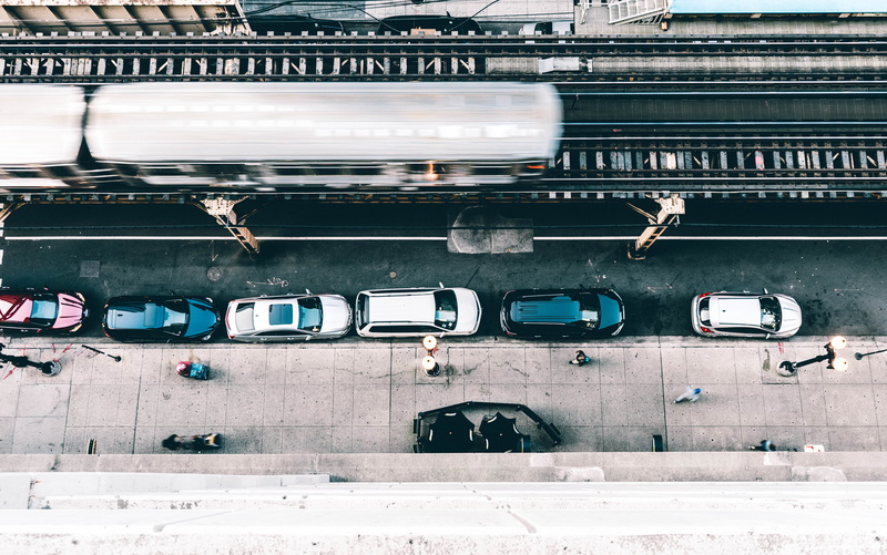 train, road, built structure, city, sidewalk, cars, looking down, travel, aerial, sign, urban, transportation, el, flat, communication, movement, photography