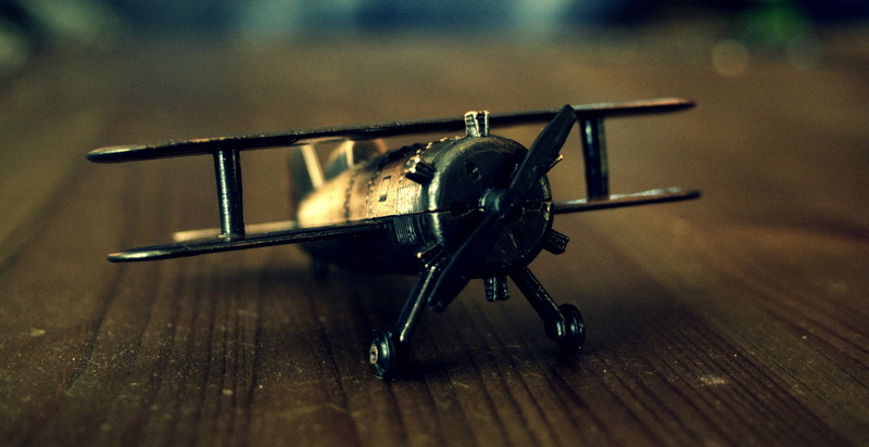 technology, history, still life, focus on foreground, plane, vehicle, shallow, wood - material, high angle view, the past, old, propeller, antique, indoors