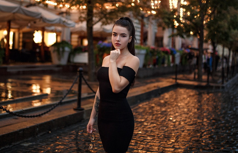 black color, adult, clothing, 2K, contemplation, elegance, leisure activity, glasses, dress, outdoors, women outdoors, black dress, fashion, beautiful people