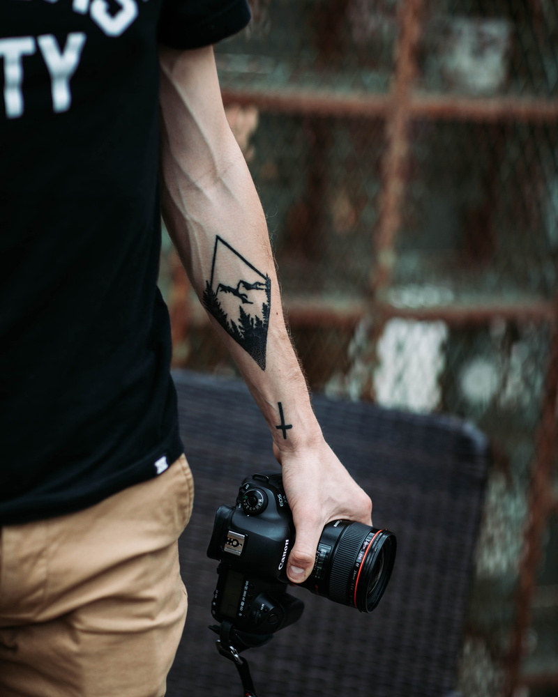 one person, electronics, photographer, hand, photo, standing, clothing, lifestyles, tattoo, human hand, human arm, focus on foreground, video camera, sports equipment