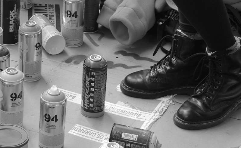 human leg, real people, finger, close-up, tag, human body part, human hand, low section, colors, graffiti, shoe, bomb, black and white, urban, high angle view