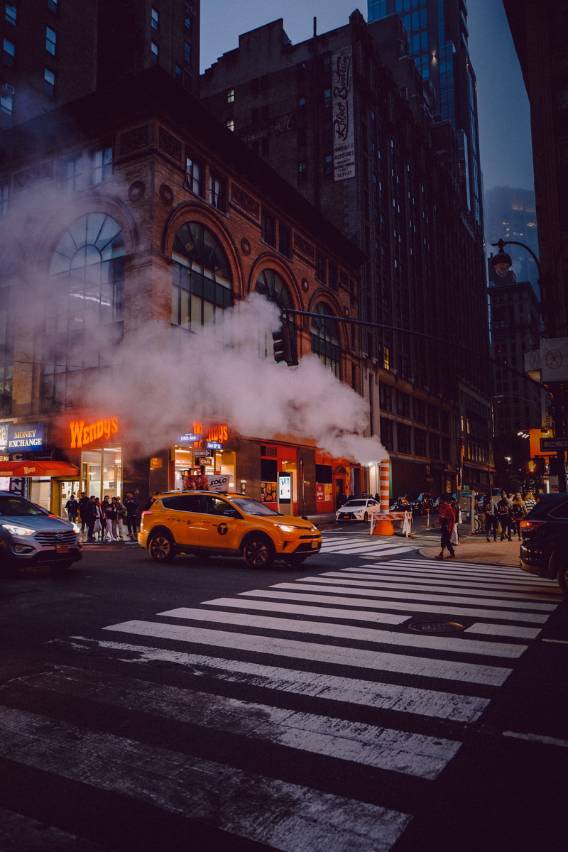 land vehicle, architecture, city, city street, city life, orange, mode of transportation, road marking, suv, street, road, built structure, pollution, motor vehicle