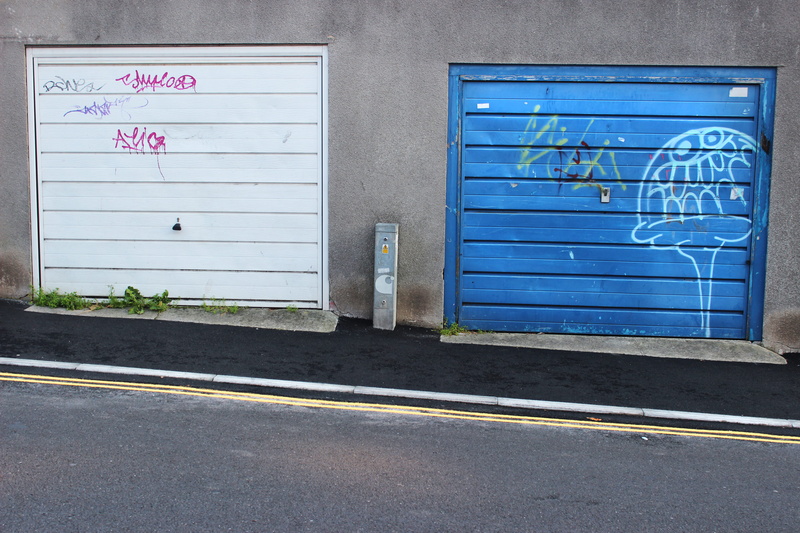 united kingdom, garages, door, doors, no people, pavement, garage, graffiti, symbol, building exterior, blue, day, road, closed, 2K, western script, street