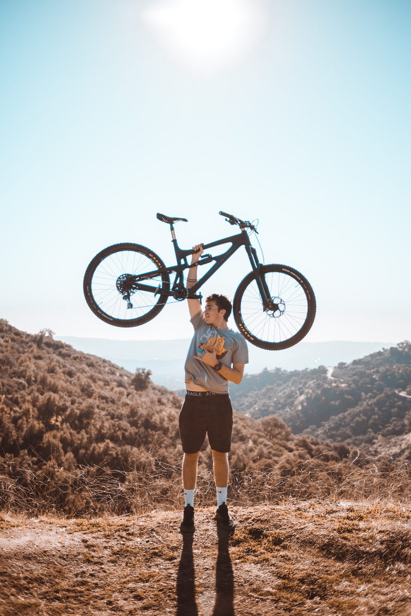 focus, suspension, day, land, bicycle, man, selective, one person, standing, right, sport, lifestyles, sunlight, lifting, bike, nature, clear sky, full length