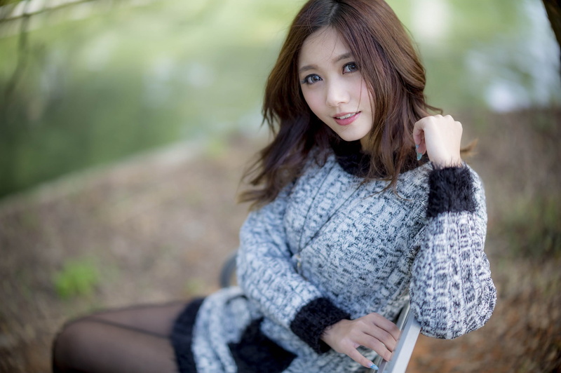 hairstyle, sitting, beautiful woman, lifestyles, brunette, outdoors, looking at viewer, Asian, front view, warm clothing, girls, brown hair, teenager, hair