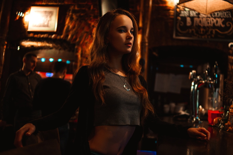 looking at viewer, crop top, dark, model, women, necklace, grey tops, 2K, women indoors, bar, long hair, depth of field, brunette, belly, indoors, Ksana Stankevich