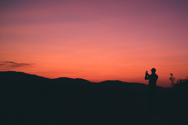 beauty in nature, men, photographing, photographer, silhouette, sunset, photography themes, pink, hiking, mobile, wireless technology, digital camera, portable information device