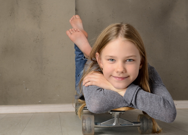 smile, looking at camera, one girl only, body part, cool, offspring, flooring, innocence, lying, women, sitting, childhood, skateboard, feet, portrait