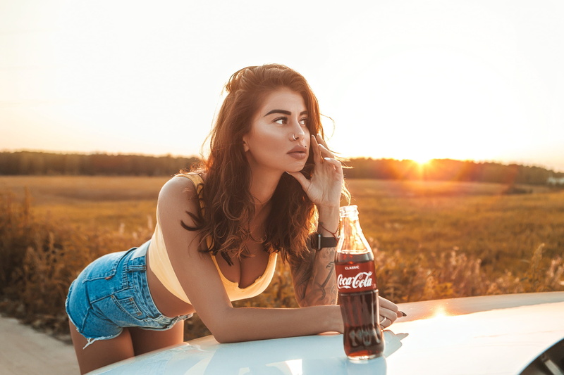 looking away, photo, model, 2K, chest, brown eyes, girl, tattoo, tank top, portrait, Coca Cola, depth of field, nose ring, mouth, cleavage, legs, jean shorts