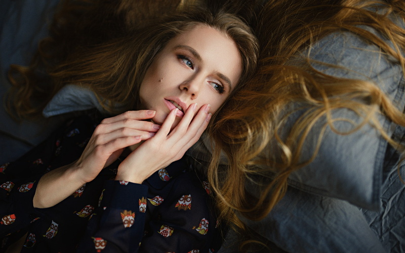 long hair, fashion, looking at camera, indoors, blue eyes, one person, real people, 1080P, lifestyles, wavy hair, Sergey Fat, lying down, beautiful woman