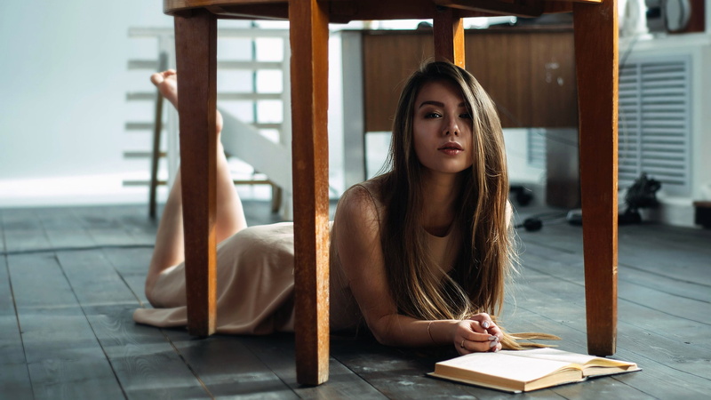 blue eyes, model, table, hair in face, feet, on the floor, long hair, brunette, dress, books, women, legs, lying on front, face, straight hair, feet in the air