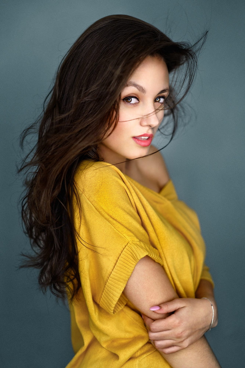 open mouth, lipstick, looking at viewer, depth of field, women, smiling, sweater, bare shoulders, messy hair, brunette, yellow clothing, jewelry, painted nails