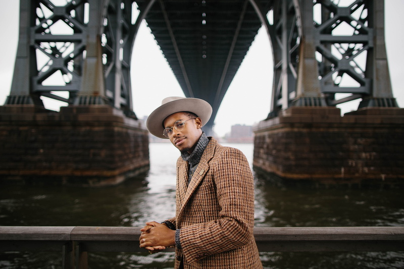 real people, 1080P, turtlenecks, bridge, standing, glasses, young men, men, African, one person, casual clothing, hat, smiling, connection, architecture