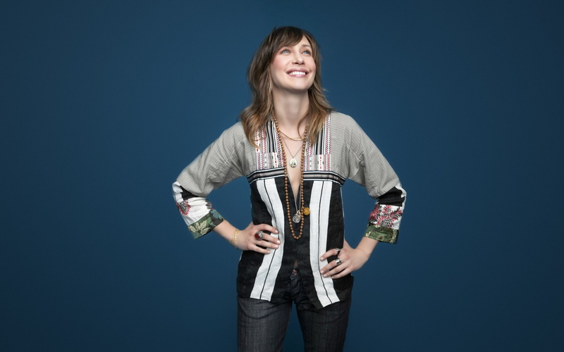 vera farmiga, one person, award, blue background, three quarter length, holding, studio shot, portrait, happiness, blue, trophy, hair, colored background